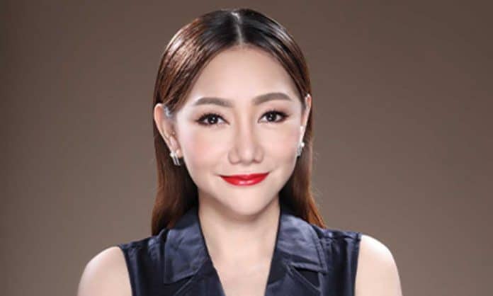 Closeup photo of Yendy Loh Yean Theng in a black sleeveless top with a brown background
