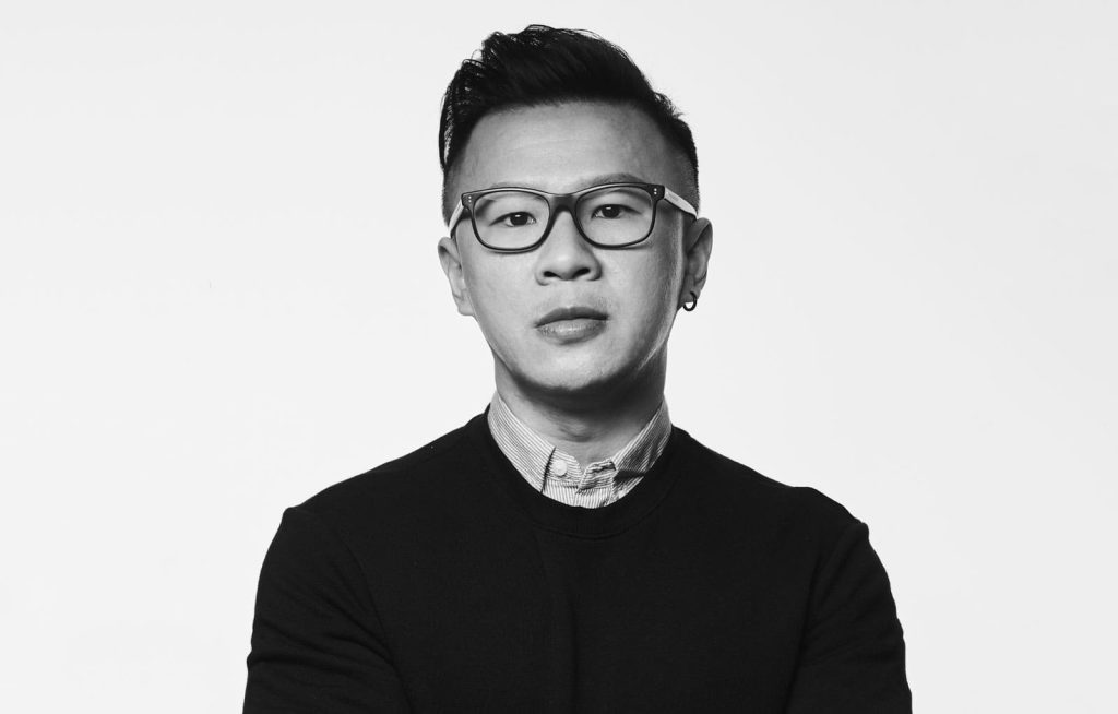 Monochrome bust portrait photo of Alvin Mong in a collared shirt and sweater