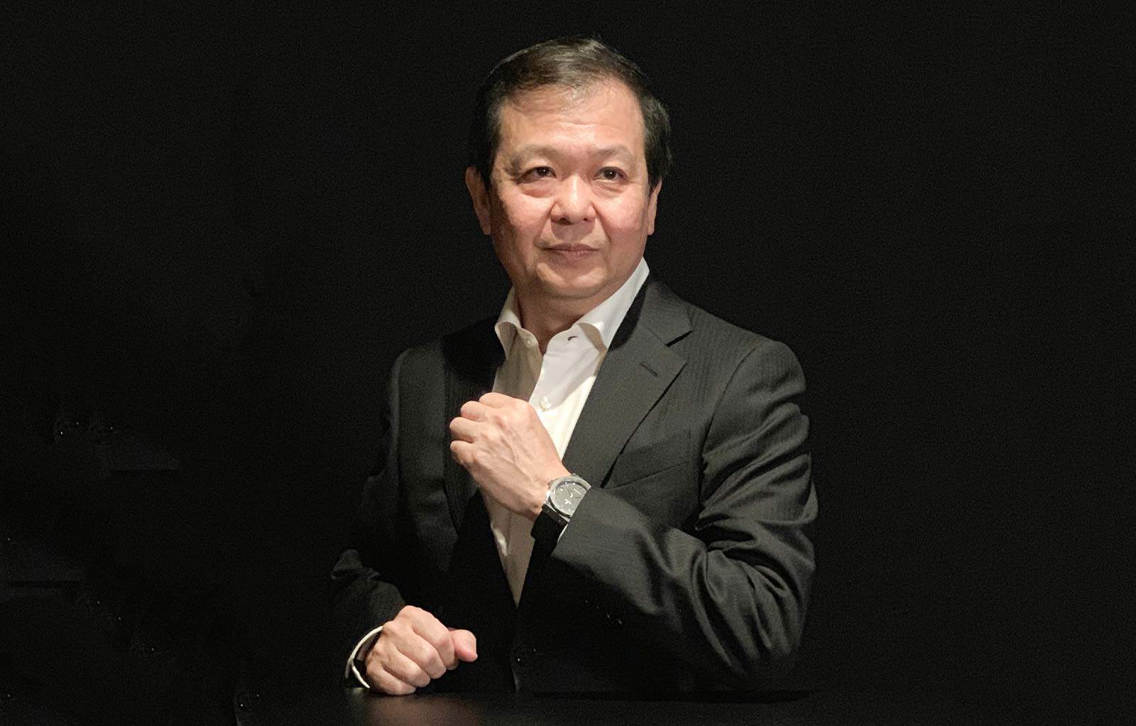 Bust portrait photo of Chia Chor Seong in a white shirt and black suit with a black background