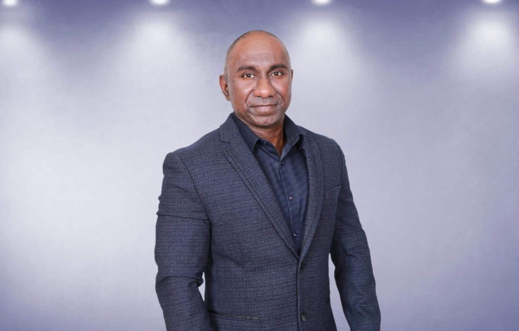 Half-body portrait photo of Dato' Mohd Anuar Bin Mohd Ibrahim in a gray suit with a light gray background and 4 lights