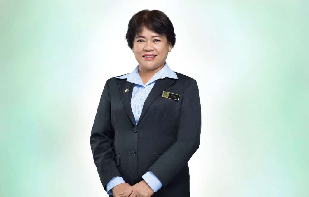 Half-body portrait photo of Serawa Budol in a light blue dress shirt and dark blue suit, standing with hands together, in front of a white-to-pale green gradient background
